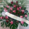 Centro de flores para funeral con rosas rojas y rosas