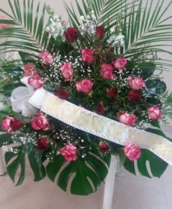 Centro de flores para funeral con rosas rojas y rosas