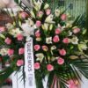 Centro de flores para funeral con rosas rosas y lilium