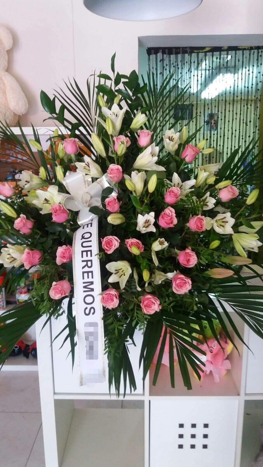 Centro de flores para funeral con rosas rosas y lilium
