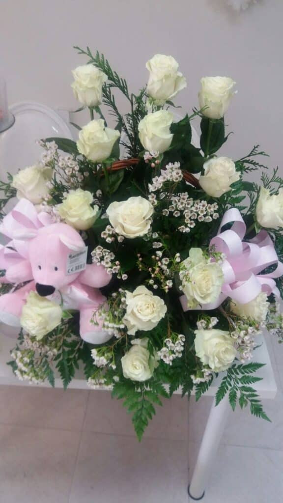 Centro con rosas blancas y peluche, un arreglo floral elegante y tierno de Floristería Sayde en Zaragoza. Perfecto para regalos especiales con entrega a domicilio.