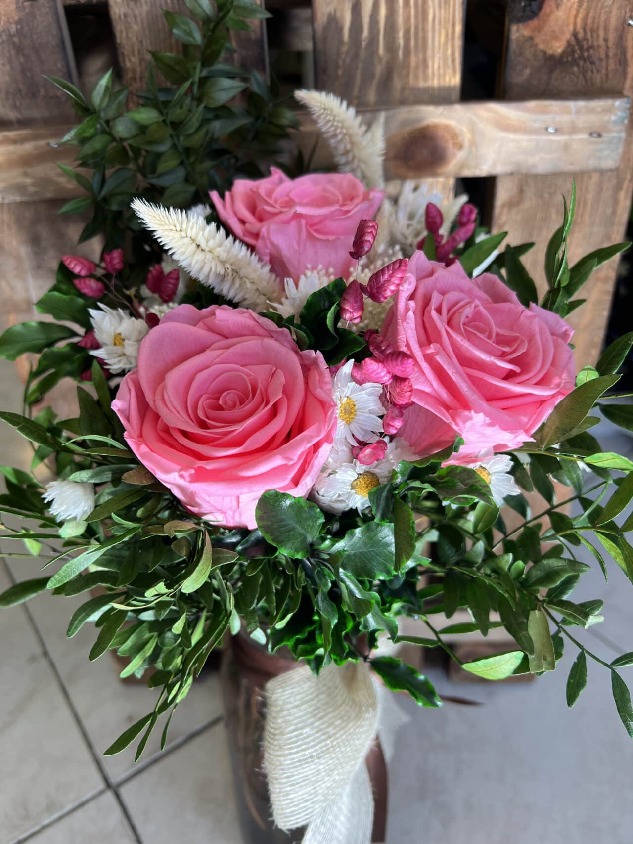 Ramo Preservado de Rosas Rosa con follaje verde, flores secas y jarrón de vidrio decorativo. Creación exclusiva de Floristería Sayde en Zaragoza.