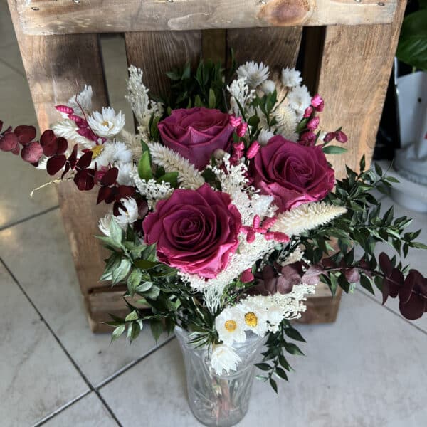 Ramo Preservado de Rosas Fucsia con follaje verde, flores secas en tonos crema y burdeos, acompañado de un jarrón decorativo de vidrio. Creación exclusiva de Floristería Sayde, Zaragoza.